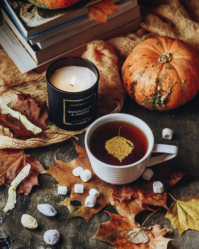 Tea with fall leaves, marshmallows, and a candle